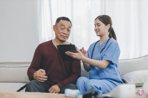 Essential Home Safety Modifications for Seniors - Nurse showing a senior man something on a digital tablet, both smiling.