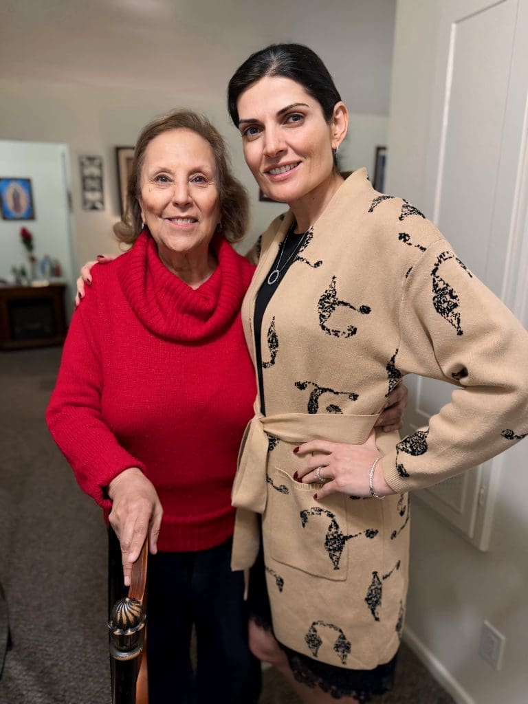 Amy helping a senior, standing side by side.