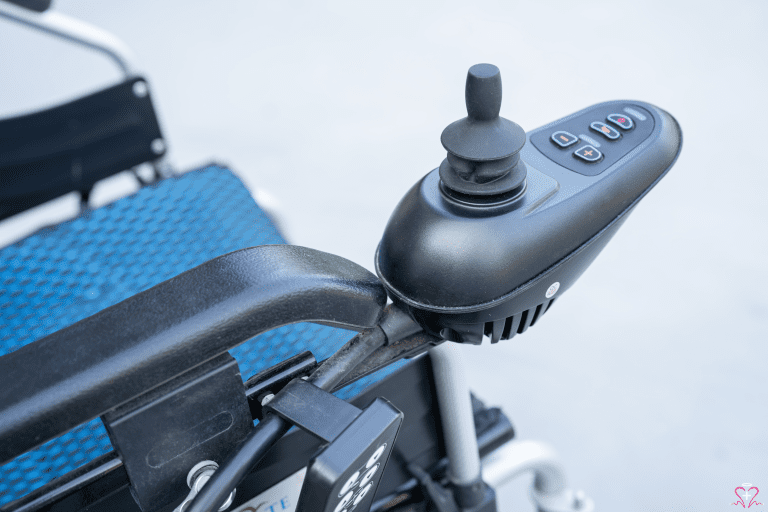 Close-up of the control joystick on an electric wheelchair.