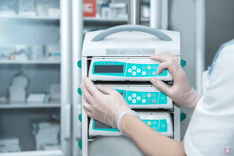 Healthcare professional adjusting an infusion pump in a medical facility.