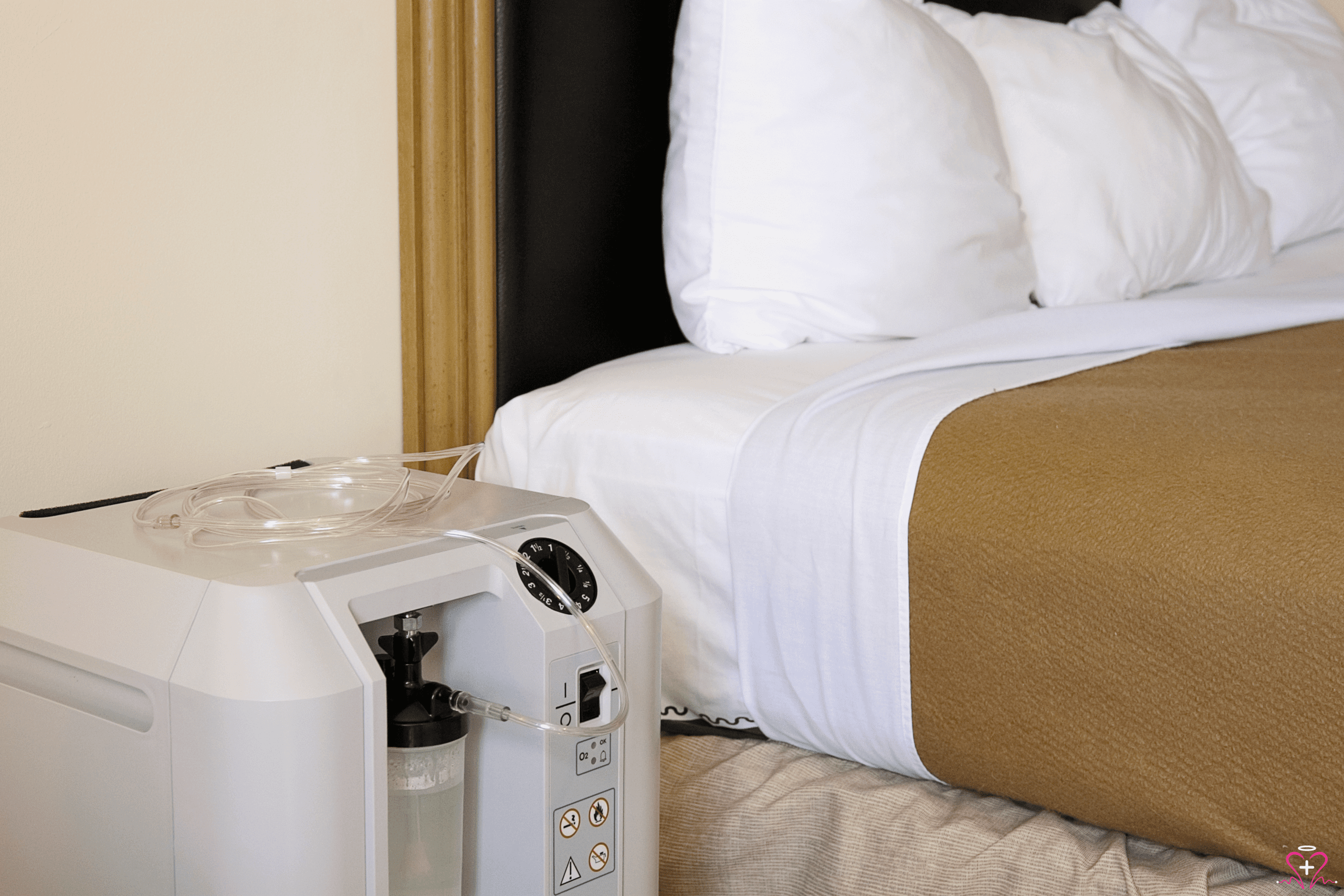 Home oxygen concentrator placed next to a bed.