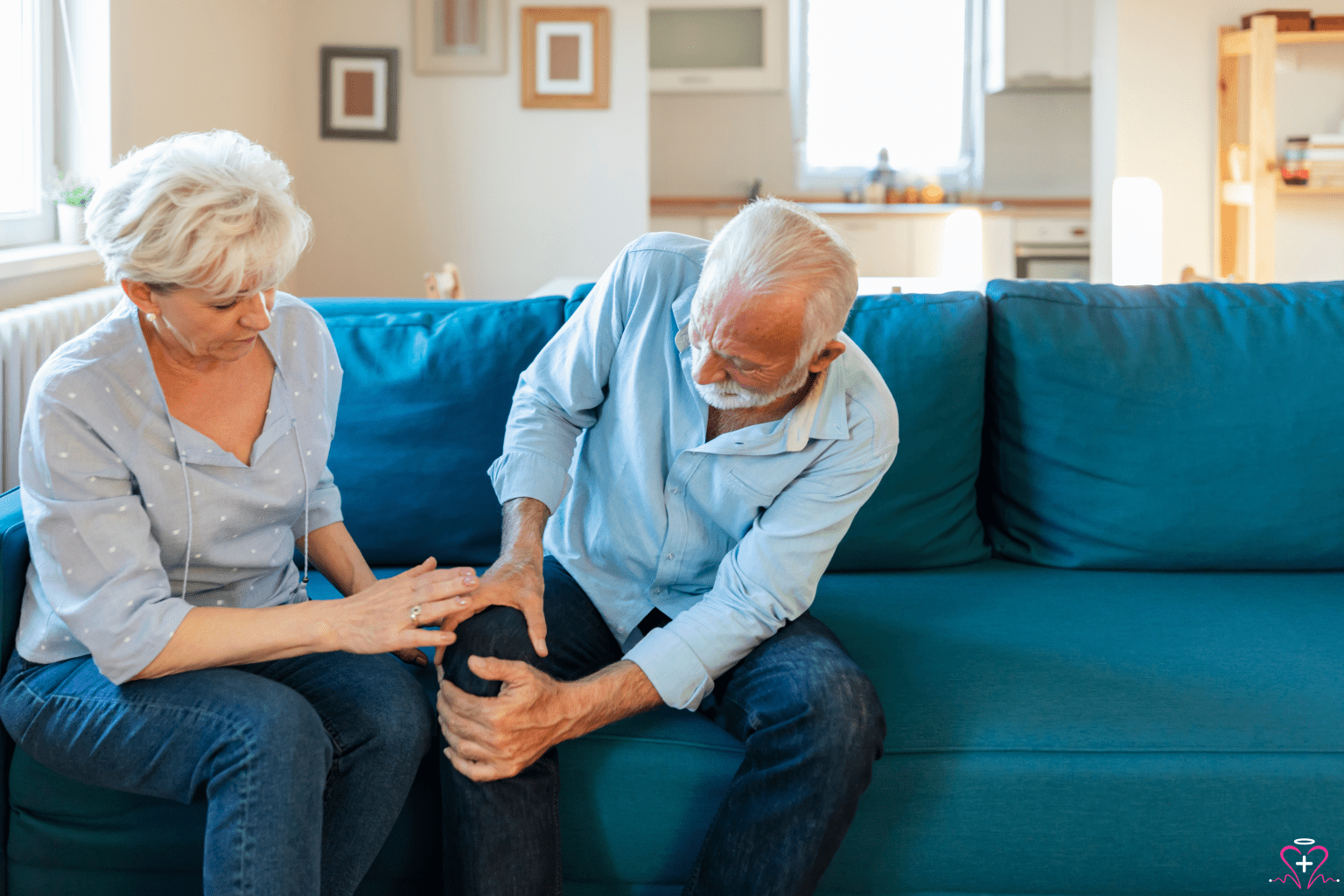 Arthritis Panel - An elderly man sitting on a blue couch, holding his knee in pain, while an elderly woman beside him looks concerned and touches his knee gently.