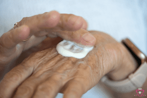 Senior person applying barrier creams on their hand.