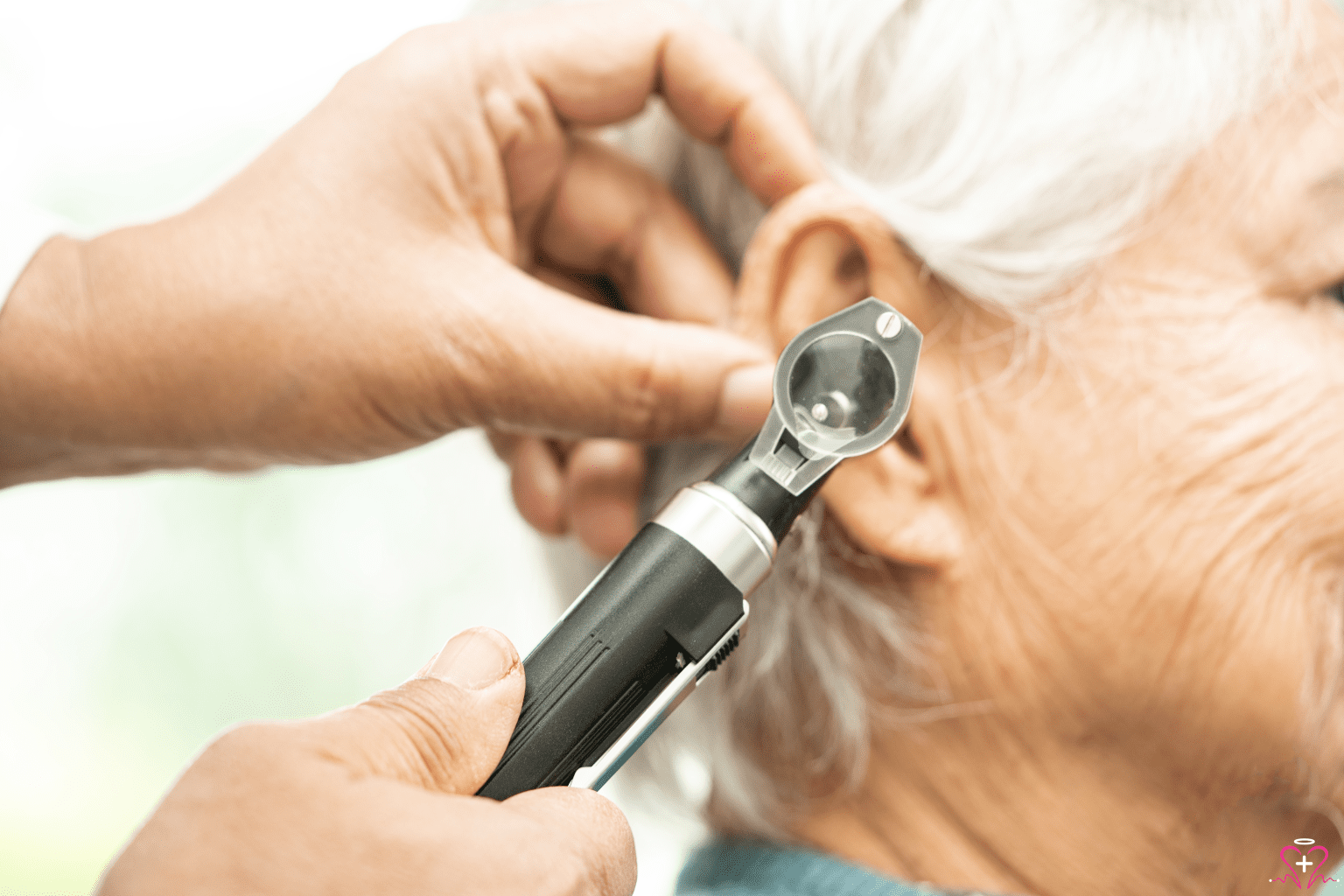 Common ENT Disorders and Treatments - Close-up of a healthcare professional examining an elderly woman's ear with an otoscope.