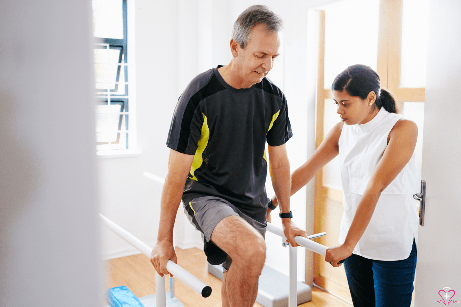 Care Coordination - A physical therapist assisting a senior man with rehabilitation exercises using parallel bars.