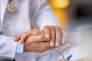 Medical Care - Close-up of a doctor holding a patient's hand, providing comfort and reassurance.