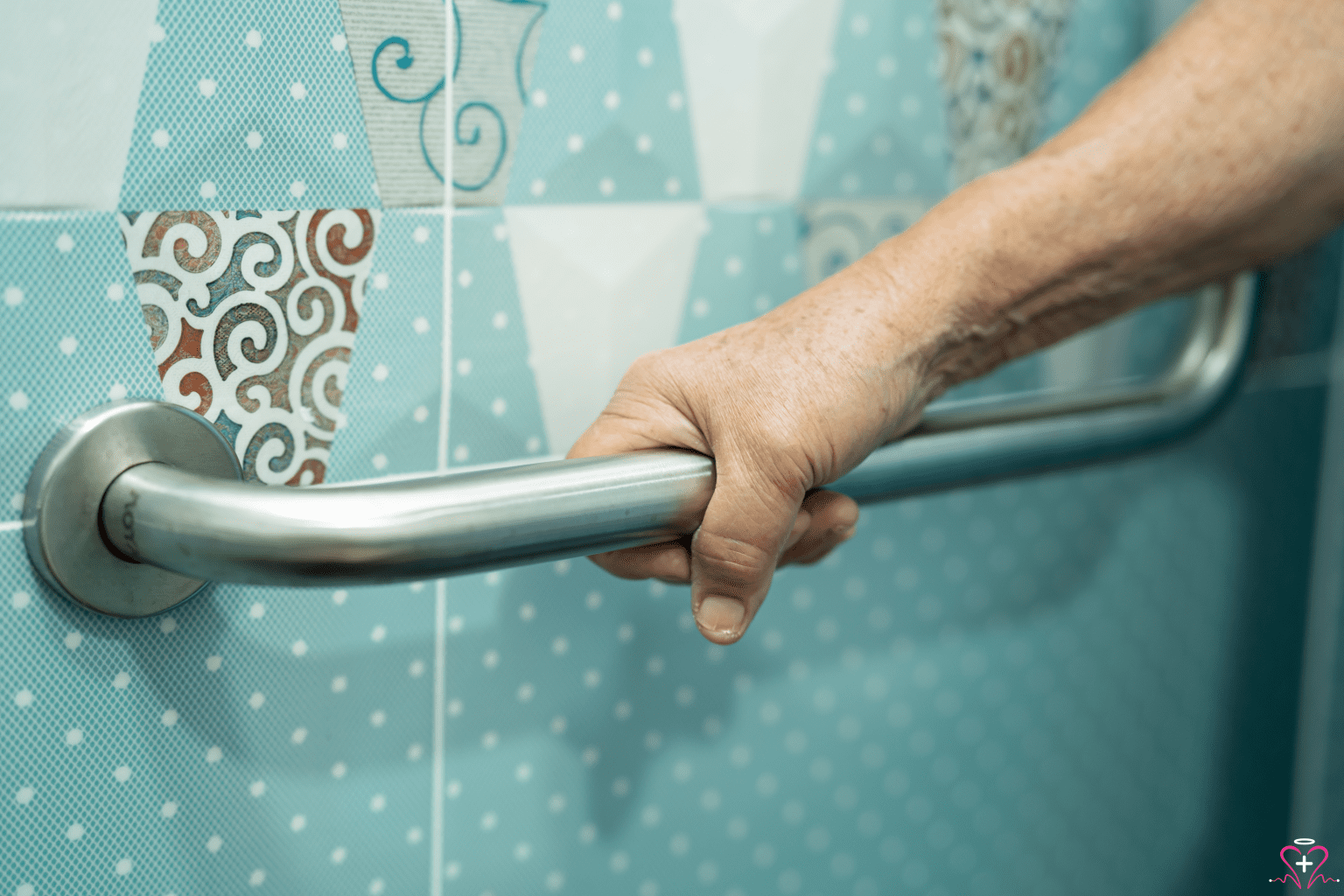 Safety Rails - A close-up of a senior person's hand gripping a safety rail in a tiled bathroom, emphasizing the importance of safety features for elderly individuals.