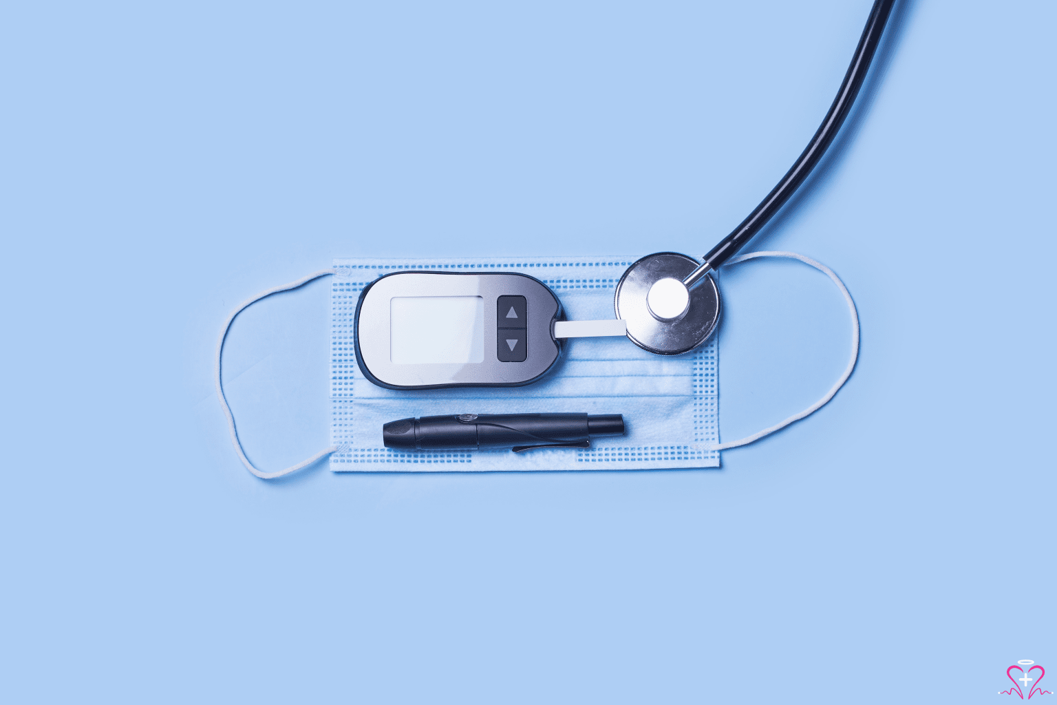 Glucose Monitors - A glucose monitor, a stethoscope, and a medical mask arranged on a light blue background, emphasizing the tools used for monitoring and managing diabetes.