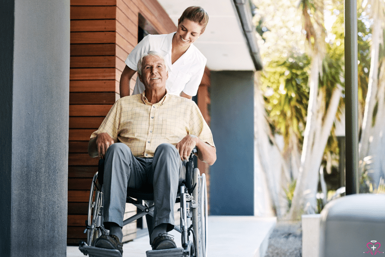 Importance of Post-Hospital Discharge Care - Caregiver assisting an elderly man in a wheelchair outdoors