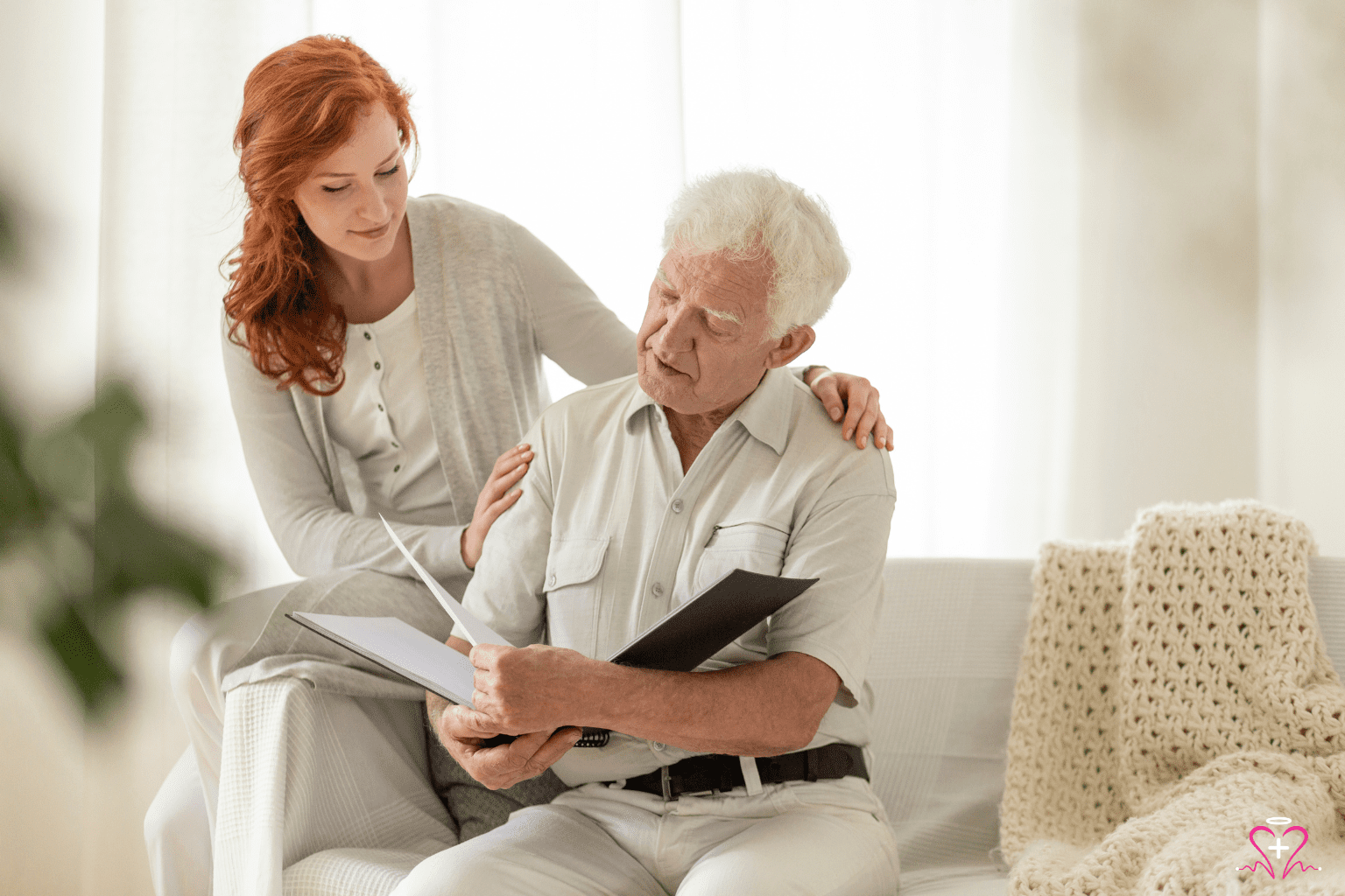 Hospice Chaplain - A compassionate woman comforting an elderly man while they review documents together.