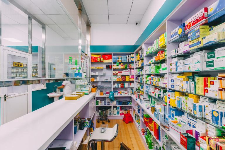 Pharmacy - A pharmacy with shelves filled with various medications and a pharmacist working behind the counter.