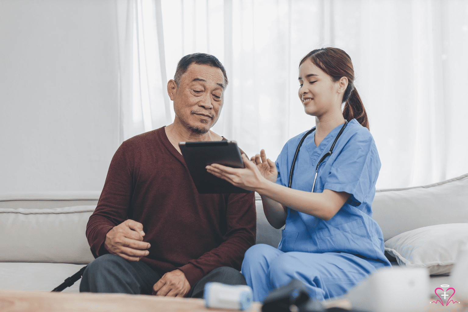 Essential Home Safety Modifications for Seniors - Nurse showing a senior man something on a digital tablet, both smiling.