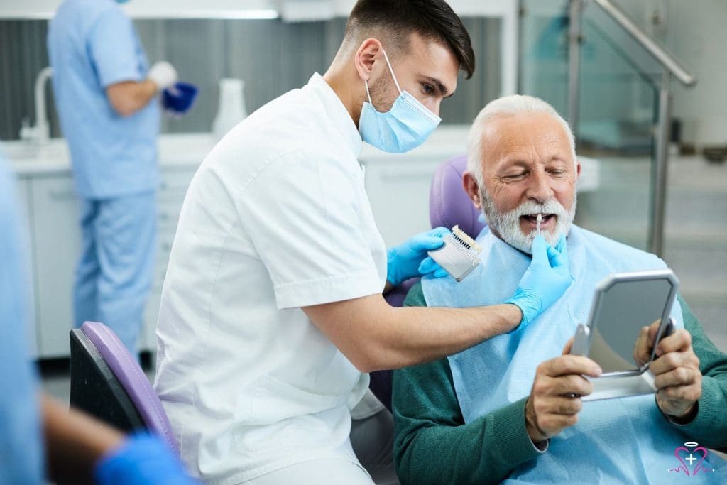 Dental Care for Seniors - Dentist assisting a senior man in choosing dental prosthetics while looking at a mirror