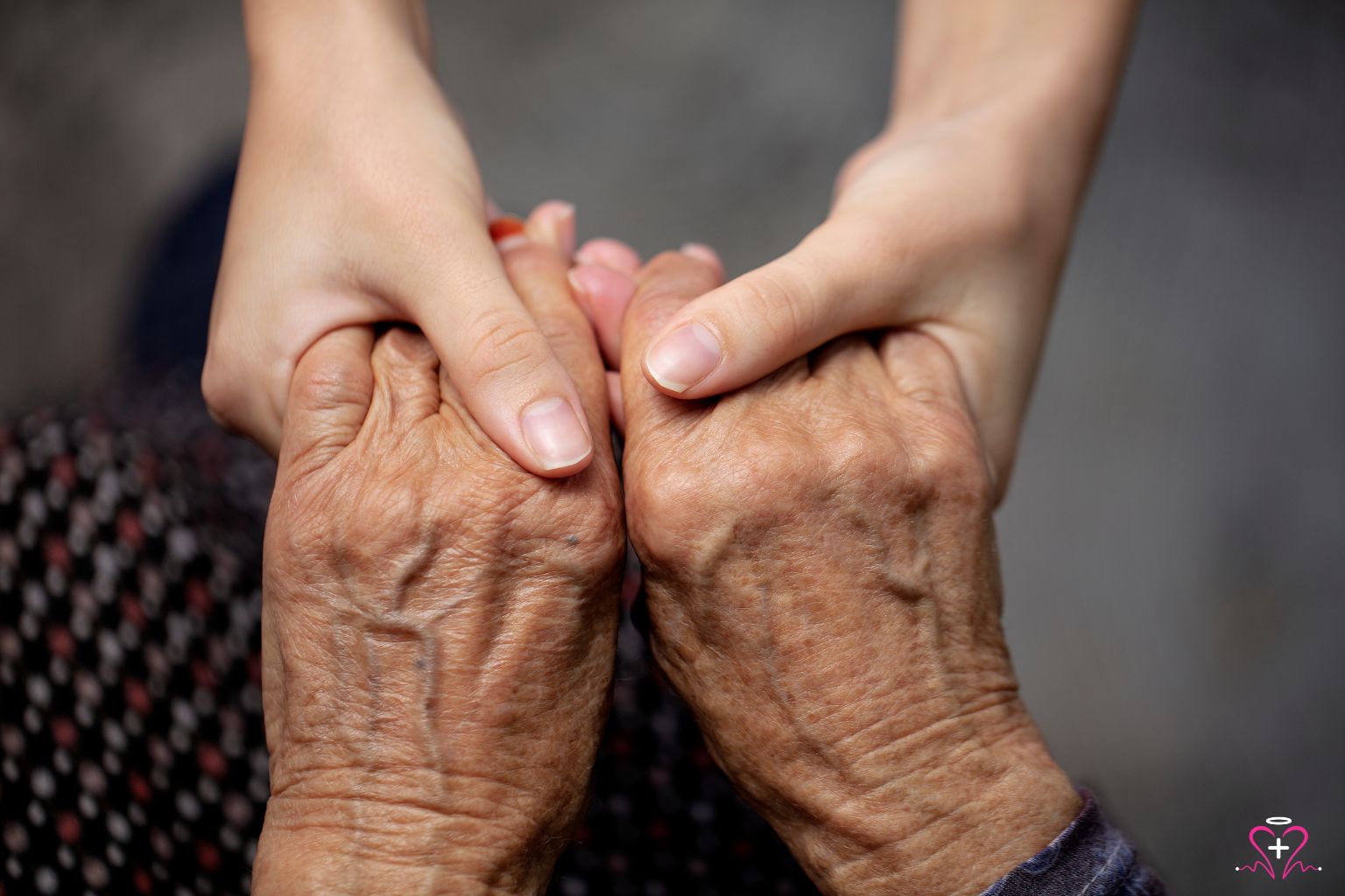 Close-up of a young person's hands holding the hands of an elderly individual, symbolizing care and compassion in elderly care.