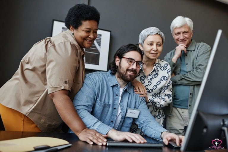 A group of diverse seniors learning computer skills from an IT teacher as part of the SCSEP program.