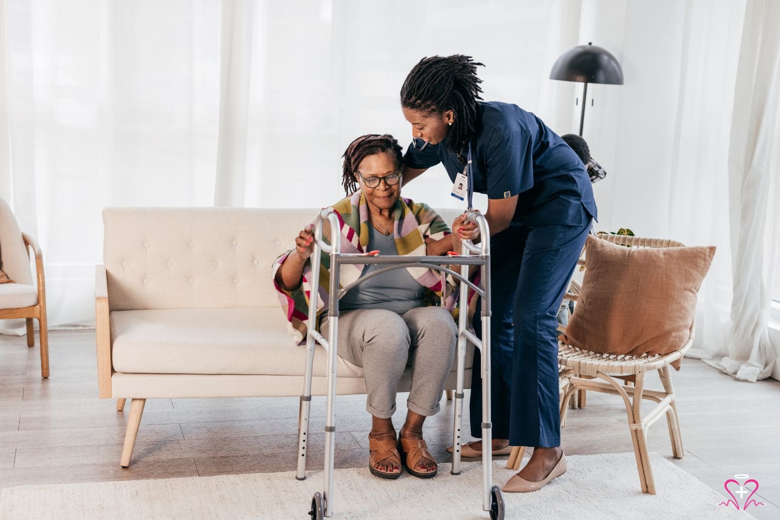 A healthcare professional assists a senior woman using a walker, providing support and care in a comfortable home setting.