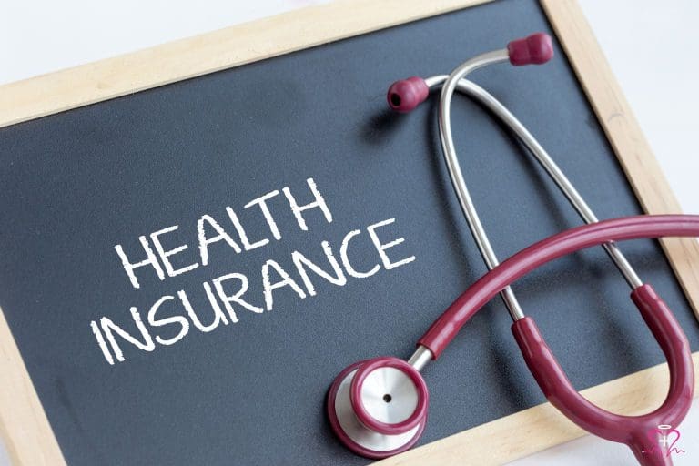 Health insurance written on a chalkboard with a red stethoscope, representing senior health solutions.