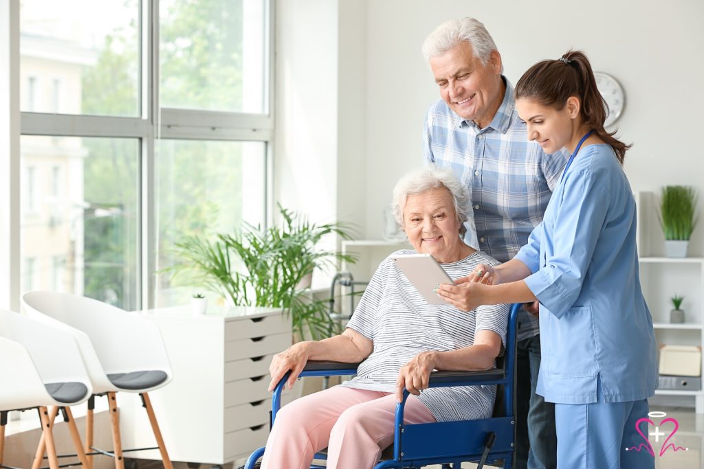 Senior woman in a wheelchair reviewing health information on a tablet with her caregiver and family member