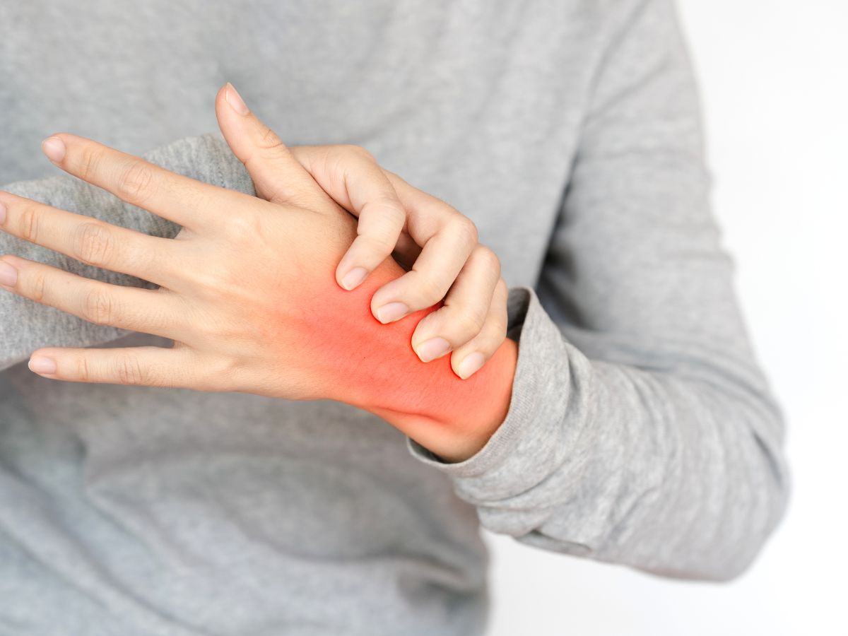 Person holding a red, inflamed wrist in pain, representing natural ways to manage arthritis pain without medication.