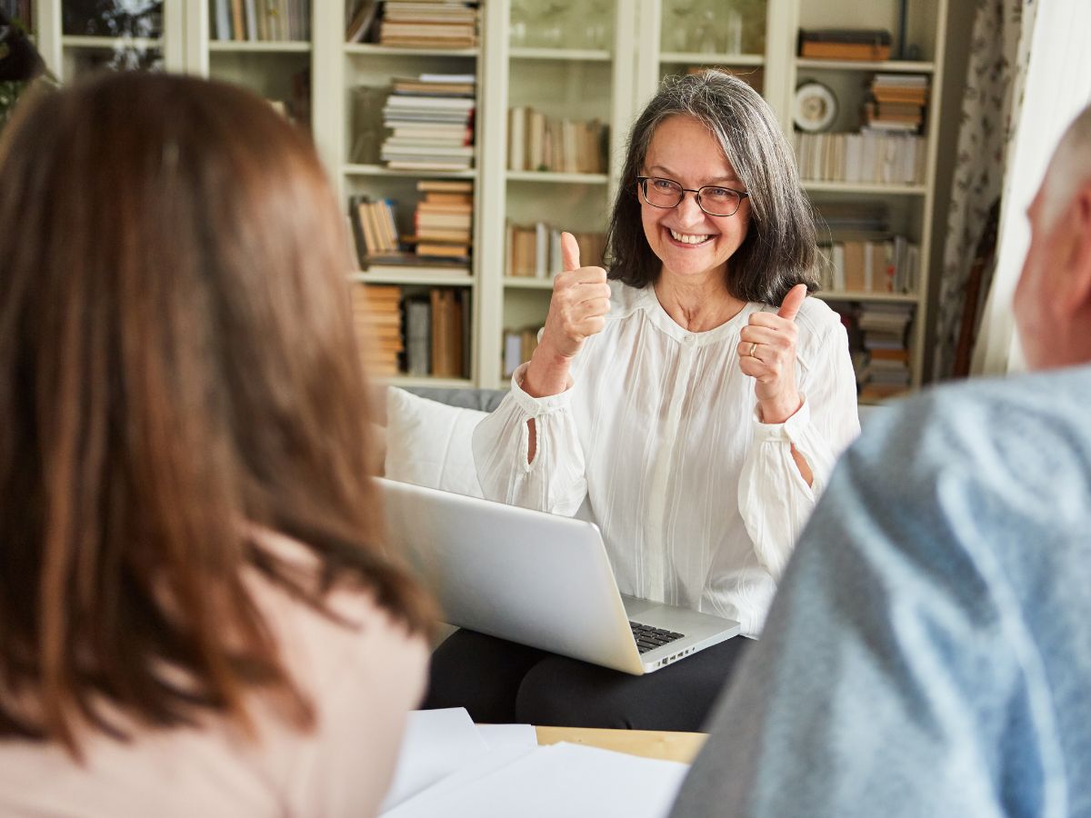 Senior couple reviewing documents with a financial advisor, representing a guide to understanding long-term care insurance for older adults.