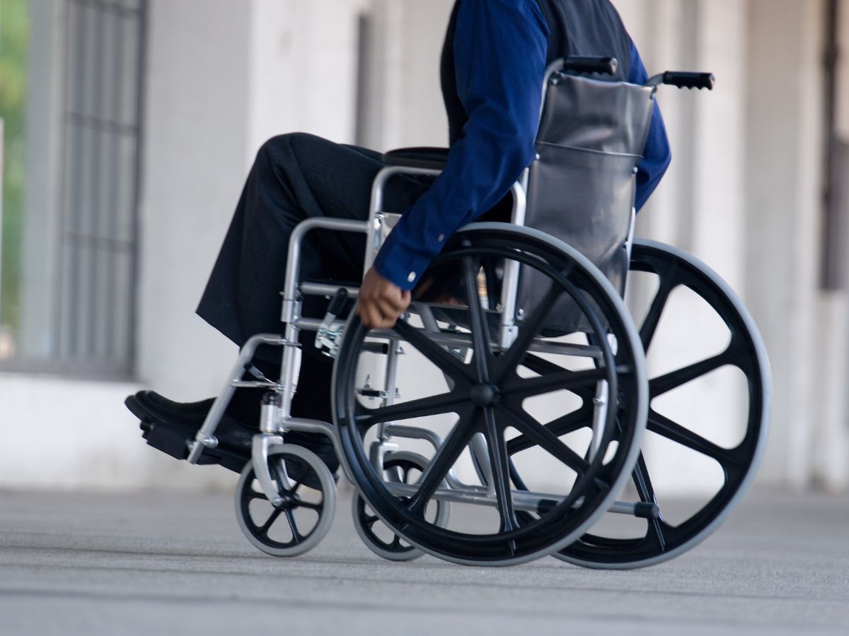 Senior man using a modern wheelchair indoors, symbolizing durable medical equipment for improved mobility.