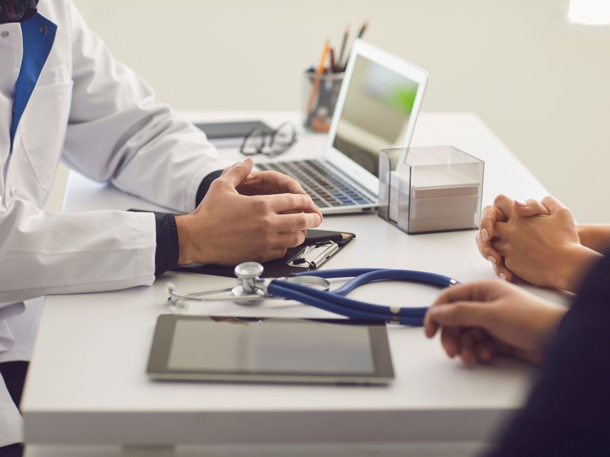 Doctor explaining Medicare healthcare coverage options to a senior patient during a consultation.