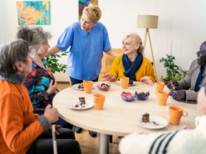 Nurse interacting with happy senior residents at a continuing care retirement community – CCRC placement and assisted living support for seniors.