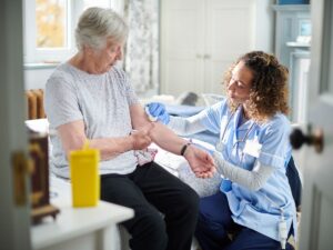 Nurse assisting an elderly woman at home – respite care placement for temporary senior support and caregiver relief in Los Angeles.