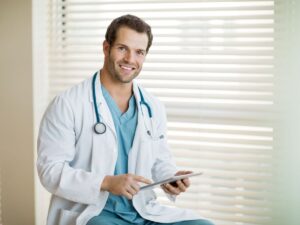 Smiling oncologist holding a tablet – find a cancer specialist for older adults providing compassionate senior oncology care in Los Angeles.