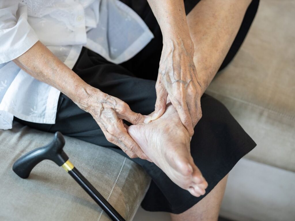 Senior woman massaging her ankle in pain – ankle pain treatment and mobility care for seniors in Los Angeles.