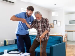 Nurse helping senior man walk with cane – Medicare coverage for home caregivers and in-home senior care in Los Angeles.