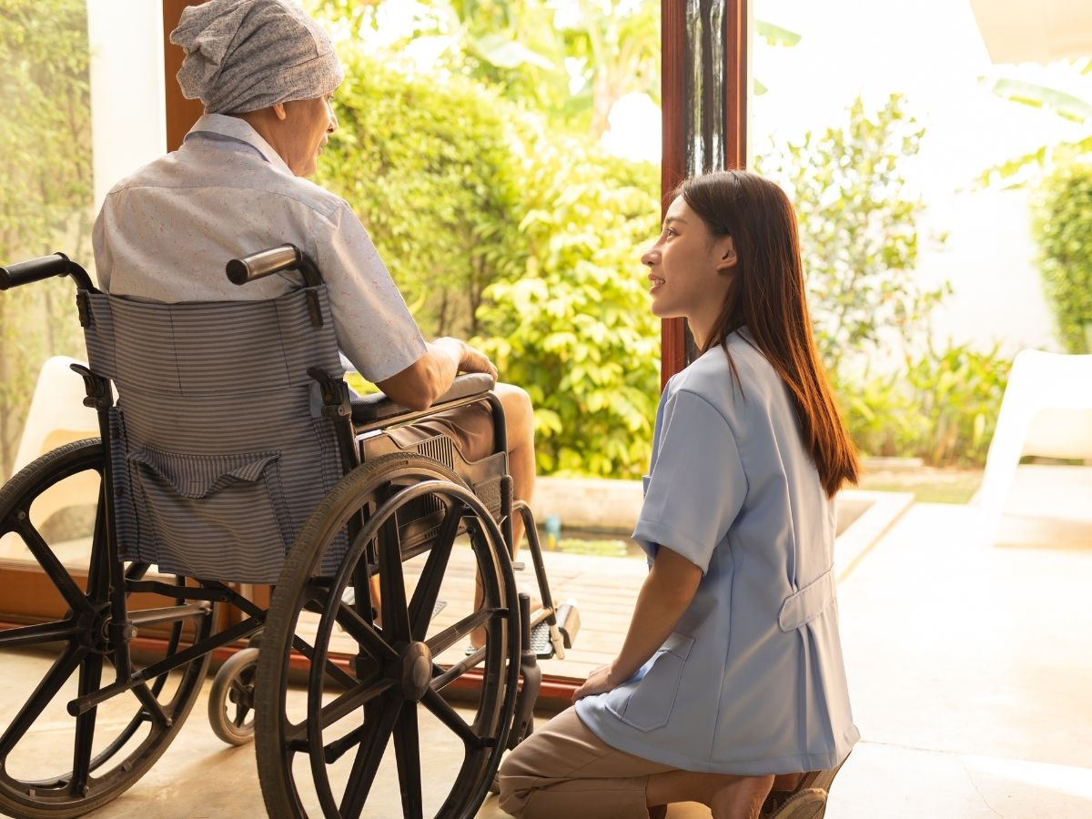 Caregiver talking with a senior in a wheelchair at home – elder care cost and home care services in Encino, Los Angeles.