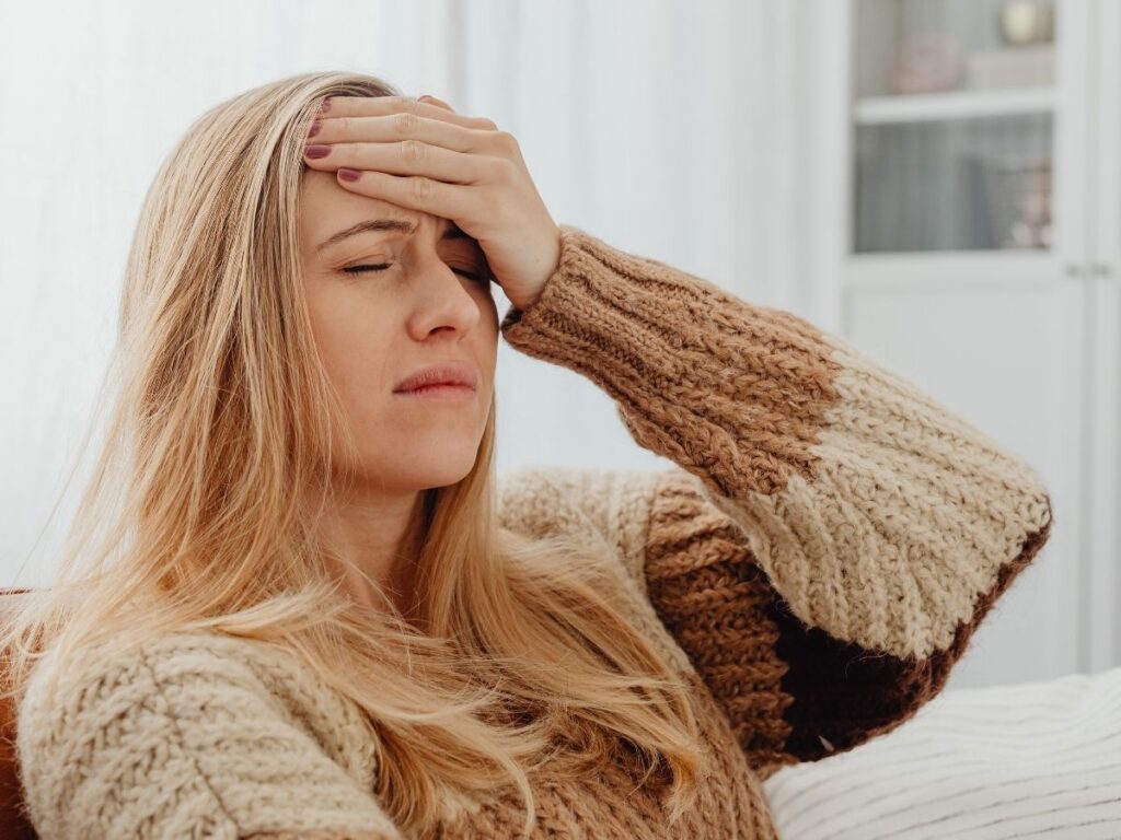 Senior woman holding her head in pain – migraine headache treatment and prevention for seniors in Los Angeles.
