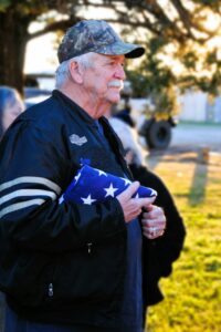 Senior veteran with American flag, illustrating veteran benefits for seniors in California
