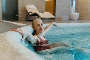 Elderly woman enjoying leisure time in an indoor pool, promoting healthy lifestyle and relaxation.
