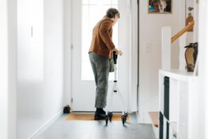 Senior adult using a rollator indoors, embracing mobility aid with confidence.